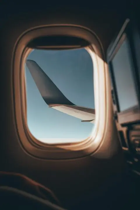 View of the wing out of a window of an airplane